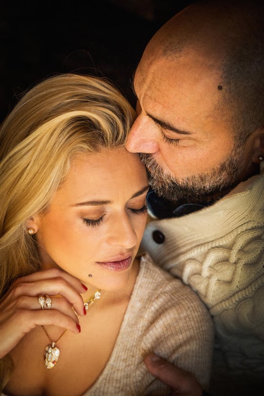 Christa Rigozzi mit Gio 2021 Hair&Make-Up/Styling: Julia Grunz Jewelry: Bulgari, Uhr: Omega, Shoes: Christa X VARESE by Ochsner Shoes Interior: Teppich by Minotti, Kissen. Kerzen, Decke by Manor, Tablet mit div. Windlichtern bei Micasa