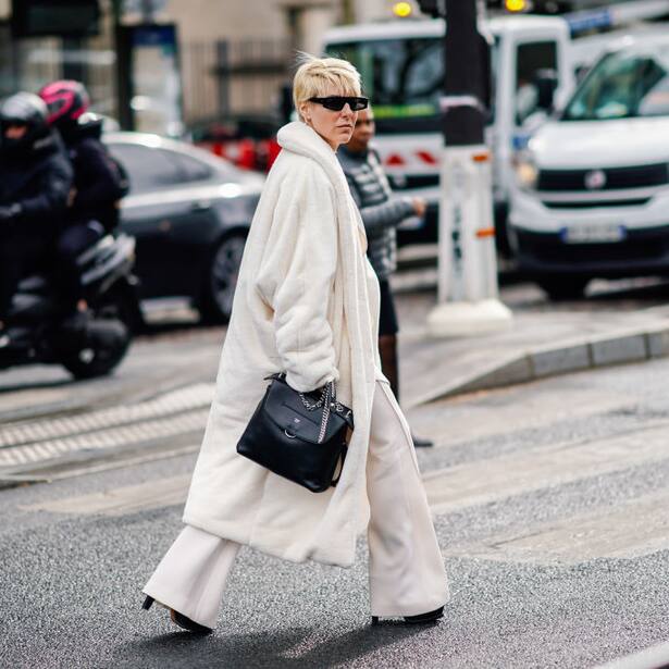 PARIS, FRANCE - MARCH 05: A guest wears sunglasses, a white fluffy coat, a black handbag, white wide-leg pants, outside Miu Miu, during Paris Fashion Week Womenswear Fall/Winter 2019/2020, on March 05, 2019 in Paris, France. (Photo by Edward Berthelot/Getty Images)