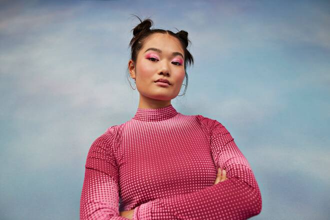 Girl with arms crossed against colored background