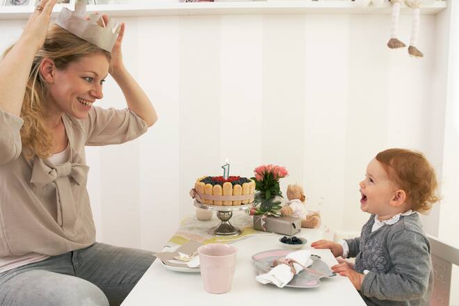 Eine Mutter setzt sich eine Papp-Krone auf