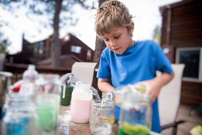 child experiments with chemicals and liquid outside