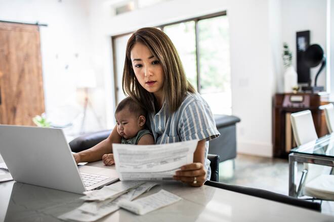 Mother working from home while holding baby
