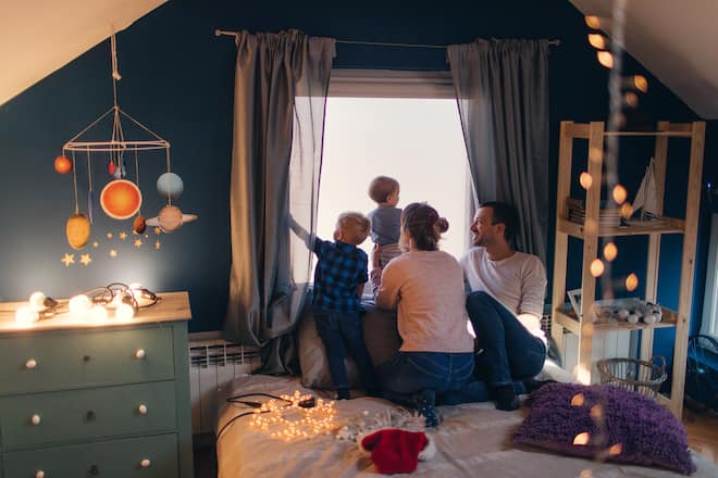 Photo of a young family with two children, enjoying Holiday season and winter magic in their home