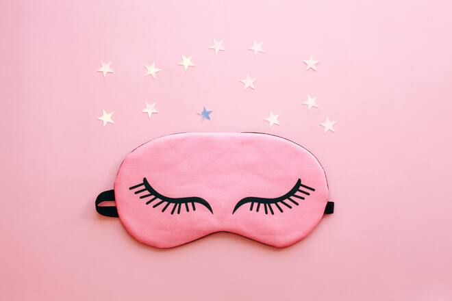 Pink sleep mask over pink background. Concept of sleep, healthy and daily routine.