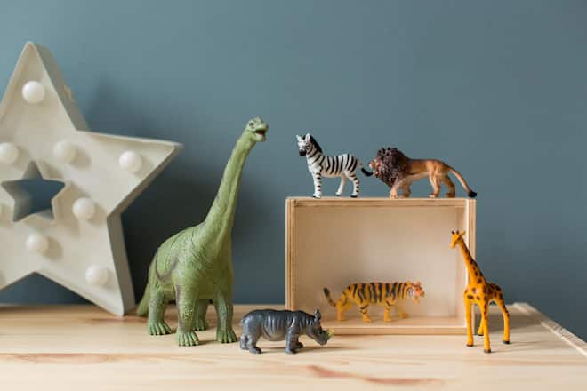 Plastic animal toys as decoration in a childrens room. Wild animals and a dinosaurus.