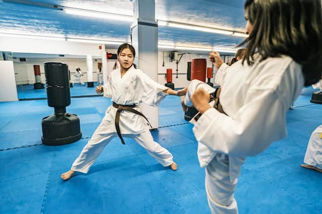 Young Karate fighters, school age children practising karate. They are all dressed in karategi-karate uniform. Interior of karate school in Mississauga, Ontario in Canada.