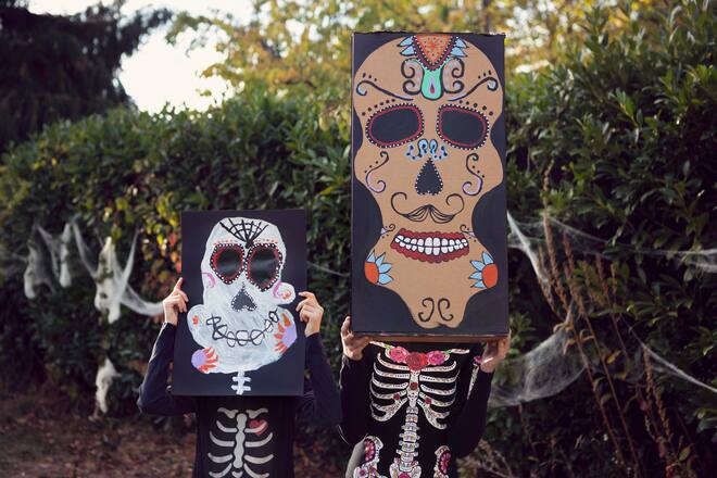 Zwei Kinder mit Halloween-Verkleidung aus Kartonkisten.