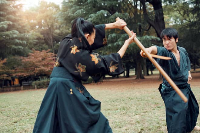 People, fight and sword in nature for martial arts, training demonstration or fitness challenge in Tokyo. Japanese kendo, teacher or outdoor with bamboo for class, culture heritage or sport tradition