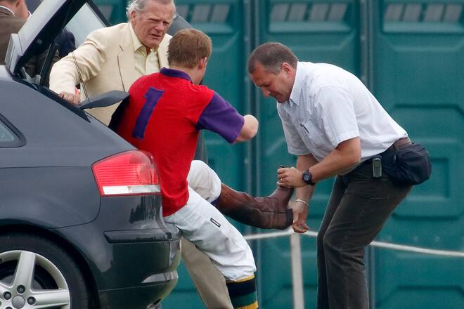 Ein Bodyguard hilft Prinz Harry aus seinen Stiefeln