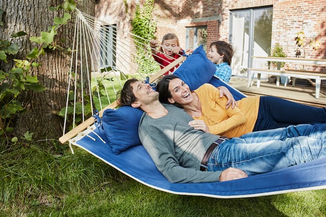 Eltern in Hängematte, Kinder schaukeln sie - Der Trend, Kinder vom Sofa aus zu bespassen, wirkt kurios, hat aber einen ernsten Kern: Eltern sind am Limit. Warum «Spielen im Liegen» legitime Notwehr ist