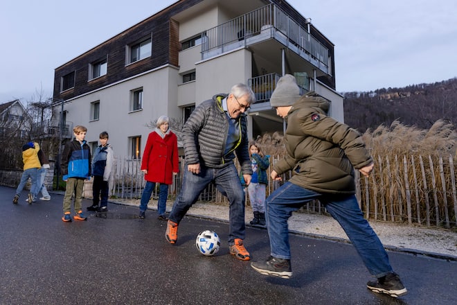 Eric Nussbaumer spielt mit seinen Enkeln im Quartier Fussball.