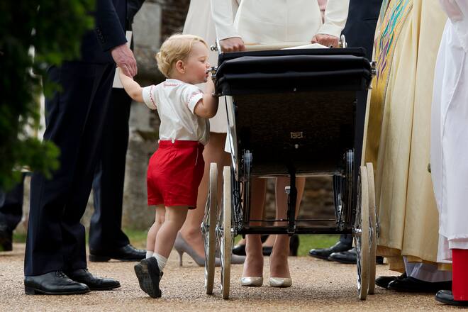 KING'S LYNN, ENGLAND - JULY 05: Catherine, Duchess of Cambridge and Prince William, Duke of Cambridge stand as Prince George of Cambridge looks into Princess Charlotte of Cambridge's pram as they leave the Church of St Mary Magdalene on the Sandringham Estate after the Christening of Princess Charlotte of Cambridge on July 5, 2015 in King's Lynn, England. (Photo by Matt Dunham - WPA Pool/Getty Images)
