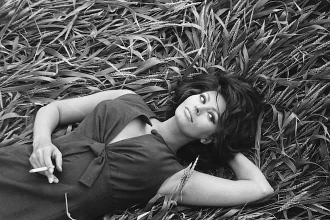 Italian actress Sophia Loren smoking a cigarette while lying in a field of corn, circa 1965. (Photo by Silver Screen Collection/Getty Images)
