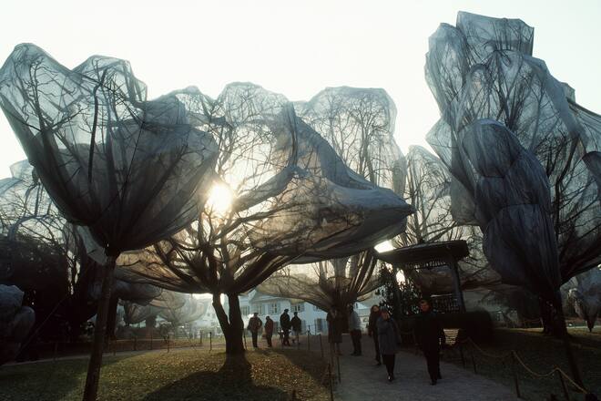 Visitors walk past wrapped trees on November 24, 1998, in Riehen near Basel, Switzerland. 'Wrapped trees' is the latest project of Bulgarian born artist Christo and his wife Jeanne-Claude. The two artists have wrapped the 163 trees in the park of the Foundation Beyeler in Riehen and the adjacent meadow. (KEYSTONE/Markus Stuecklin) === DIESES BILD DARF NUR IM ZUSAMMENHANG MIT DEM ERWAEHNTEN PROJEKT VERWENDET WERDEN, EDITORIAL USE ONLY, , SAT OUT === ===
