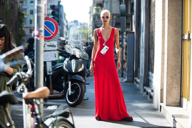 MILAN, ITALY - SEPTEMBER 23: Model Dilone wears white sunglasses, a red sleeveless dress and her iPhone around her neck after the Dolce & Gabbana show during Milan Fashion Week Spring/Summer 2019 on September 23, 2018 in Milan, Italy.