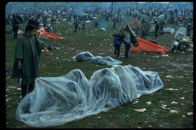 NEW YORK, UNITED STATES - AUGUST 1969: Several youths huddled together under a piece of clear plastic in the rain during the Woodstock Music & Art Fair. (Photo by John Dominis/The LIFE Picture Collection via Getty Images)
