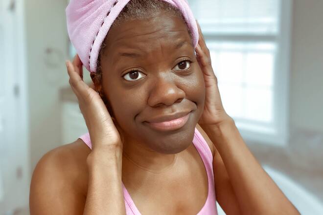 Mid adult black woman wears microfiber wrap to dry her hair after washing