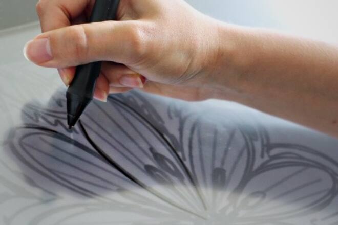 Lingerie Designerin zeichnet Blume auf iPad.