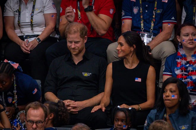 Meghans Hand auf Harrys Knie drückt Intimität aus.