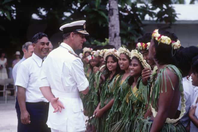 KIRIBATI - OCTOBER 23: Prince Philip the Duke of Edinburgh chats to local children in native dress on the island of Kiribati on October 23, 1983 during the Royal Tour of the South Pacific. (Photo by David Levenson/Getty Images)