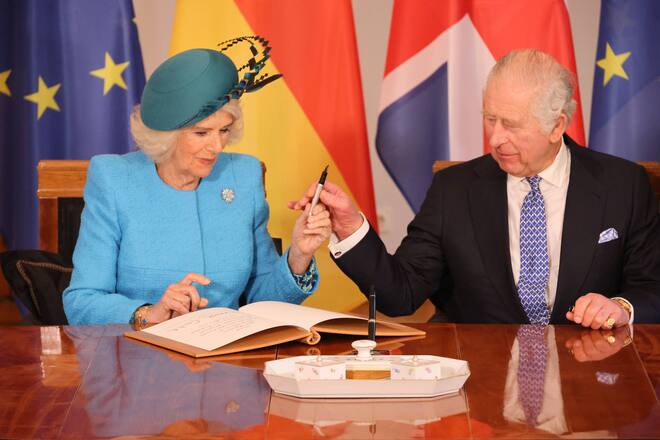 King Charles und Queen Consort Camilla tragen sich ins Goldene Buch ein.