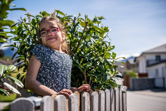 ZIZERS GR, 08.05.2021 - Julia an ihrem Lieblingsplatz bei ihrem Haus in Zizers. Von hier aus kann sie die Leute auf der Strasse oder im gegenueberliegenden Schrebergarten beobachten. Die 7 jaehrige Julia leidet unter dem Sanfilippo-Syndrom, besser bekannt unter Kinderdemenz. PHOTO BY PASCAL MORA