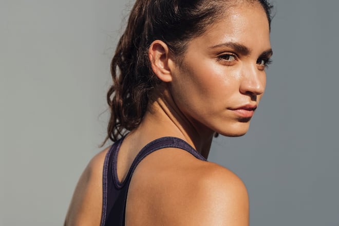 Pretty Caucasian woman in sportswear standing outdoors ready to exercise or run.