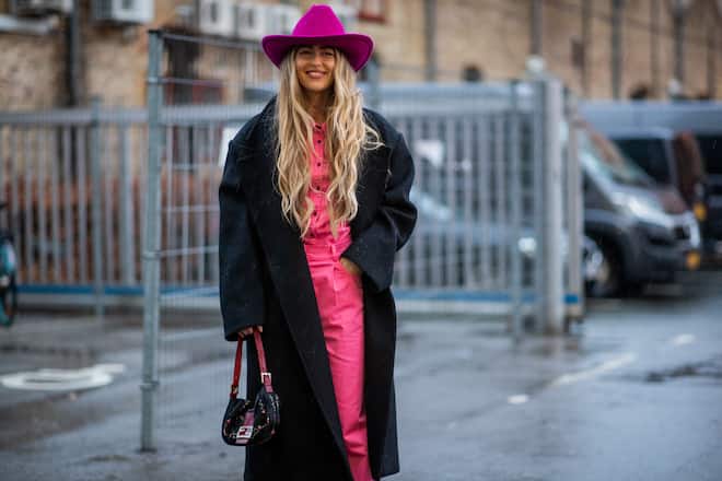 COPENHAGEN, DENMARK - FEBRUARY 01: Emili Sindlev seen wearing purple cowboy hat, pink pants and button up shirt, black coat, Fendi bag outside Rabens Saloner during Copenhagen Fashion Week Autumn/Winter 2022 on February 01, 2022 in Copenhagen, Denmark. (Photo by Christian Vierig/Getty Images)