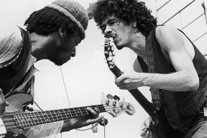 August 1969: Mexican-born guitarist Carlos Santana (right) and bassist David Brown perform with the group Santana at the Woodstock Music Festival in Bethel, New York. (Photo by Tucker Ransom/Hulton Archive/Getty Images)
