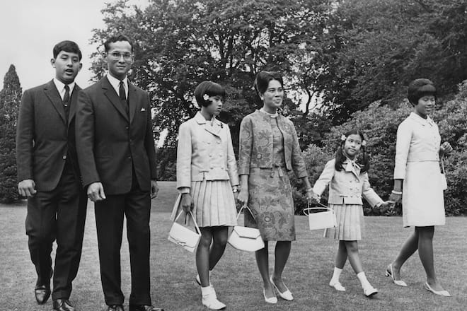 Bhumibol Adulyadej (1927 - 2016), King of Thailand, and Queen Sirikit with their children at a photocall at King's Beeches, their private residence in Sunninghill, Berkshire, 27th July 1966. Left to right, Crown Prince Maha Vajiralongkorn, the King, Princess Sirindhorn, the Queen, Princess Chulabhorn and Princess Ubol Ratana, 28th July 1966. (Photo by Central Press/Hulton Archive/Getty Images)