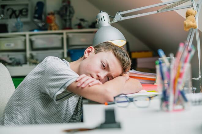 Müder Student am Schreibtisch