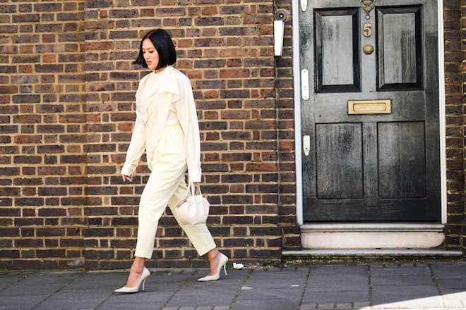 LONDON, ENGLAND - SEPTEMBER 14: Tiffany Hsu wears a scarf, a white flowy top, pale yellow cropped pants, white heels shoes, a bag, during London Fashion Week September 2019 on September 14, 2019 in London, England. (Photo by Edward Berthelot/Getty Images)