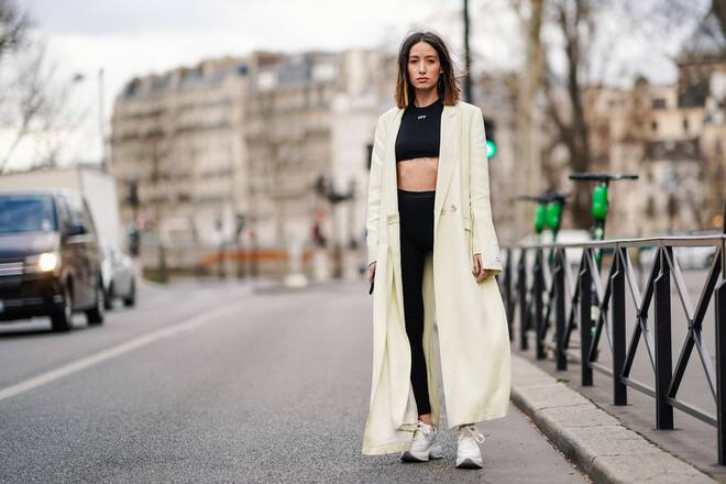 PARIS, FRANCE - FEBRUARY 28: Alexandra Guerain wears earrings,  a cream-color long coat, an Off-White black crop top, black sport pants, Hogan white sneakers, outside Redemption, during Paris Fashion Week Womenswear Fall/Winter 2019/2020, on February 28, 2019 in Paris, France. (Photo by Edward Berthelot/Getty Images)