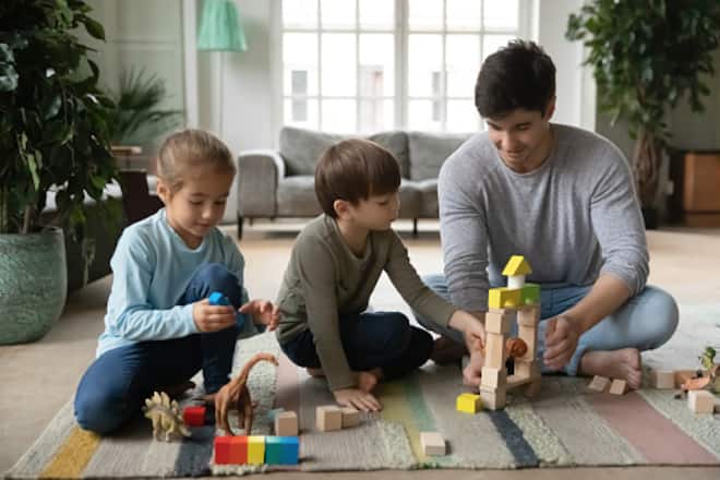 Junger Babysitter spielt mit zwei Kindern