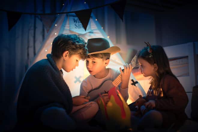 Zwei Freunde und kleine Schwester spielen Camping