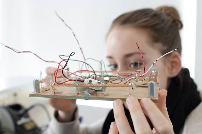 Young-woman-holding-component-for-an-optical-sensor-in-an-electronic-workshop_original.jpg