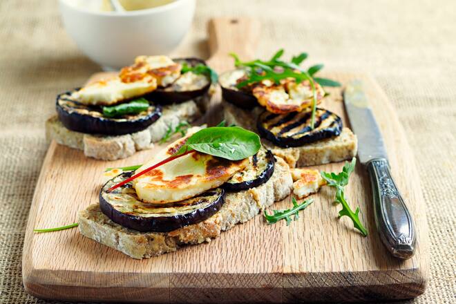 Home made healthy vegetarian open sandwich.grilled aubergine with grilled halloumi cheese and rocket leaves tahini paste,wheaten bread