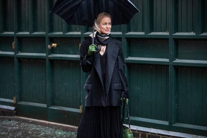LONDON, ENGLAND - FEBRUARY 16: Thora Valdimars is seen wearing headscarf, black blazer, pleated dress, green bag and gloves with snake print outside Preen during London Fashion Week February 2020 on February 16, 2020 in London, England. (Photo by Christian Vierig/Getty Images)
