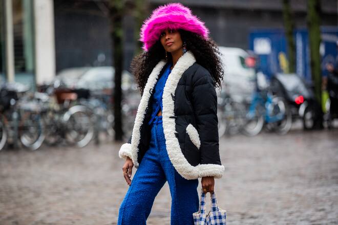 COPENHAGEN, DENMARK - FEBRUARY 03: Mona M. Ali seen wearing pink hat, shearling jacket, blue pants, white blue checkered bag outside Zalando Awards during Copenhagen Fashion Week Autumn/Winter 2022 on February 03, 2022 in Copenhagen, Denmark. (Photo by Christian Vierig/Getty Images)