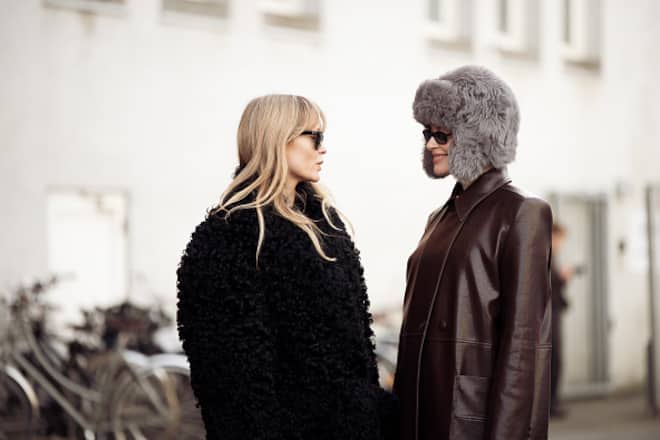 COPENHAGEN, DENMARK - JANUARY 28: Jeanette Madsen wears long black boots, black long fluffy coat and sunglssas and Thora Valdimars wears grey boots, brown leather coat and grey fluffy hat on ears outside the Nicklas Skovgaard show during the Copenhagen Fashion Week Autumn/Winter 2025 on January 28, 2025 in Copenhagen, Denmark. (Photo by Raimonda Kulikauskiene/Getty Images)