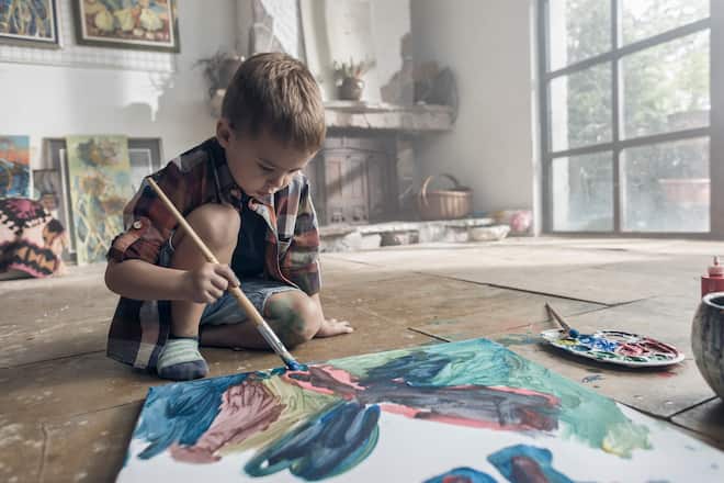 Young boy painting in an atelier.
