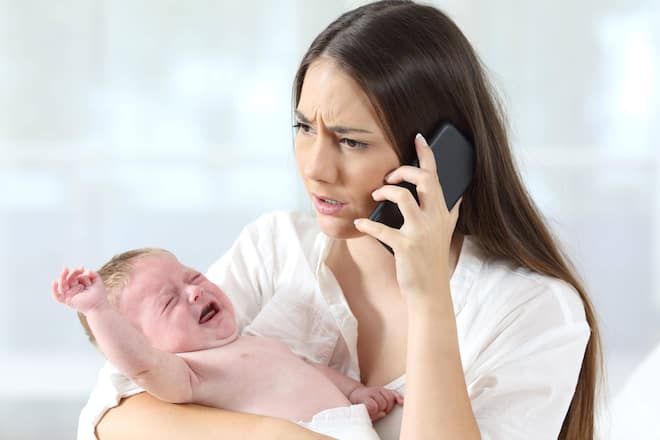 Mother calling to a doctor worried about her baby crying ,model released, Symbolfoto PUBLICATIONxINxGERxSUIxAUTxONLY Copyright: xAntonioGuillemx Panthermedia26549822
