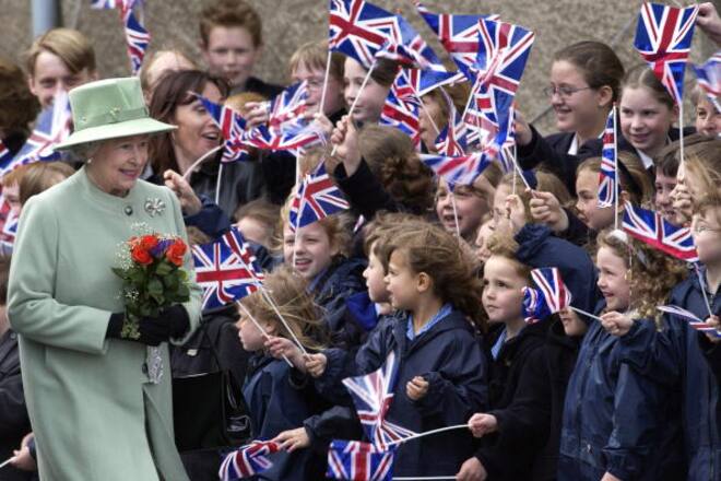 WELLS, UNITED KINGDOM - MAY 02: Smiling At The Warmth Of Her Welcome, Queen Elizabeth II Continuing Her Tour Of The Uk In Celebration Of Her Golden Jubilee Is Here On A Walkabout And Meeting Schoolchildren Waving Their Union Jack Flags. (Photo by Tim Graham Photo Library via Getty Images)