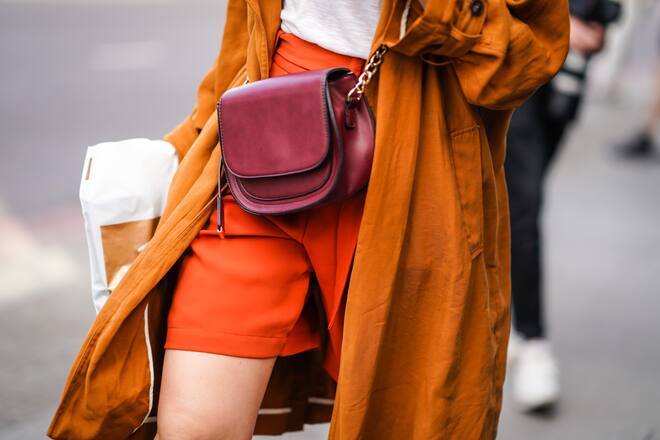 LONDON, ENGLAND - JUNE 09: A guest wears an orange trench coat, a red bag, saffron-color shorts, during London Fashion Week Men's June 2019 on June 09, 2019 in London, England. (Photo by Edward Berthelot/Getty Images)