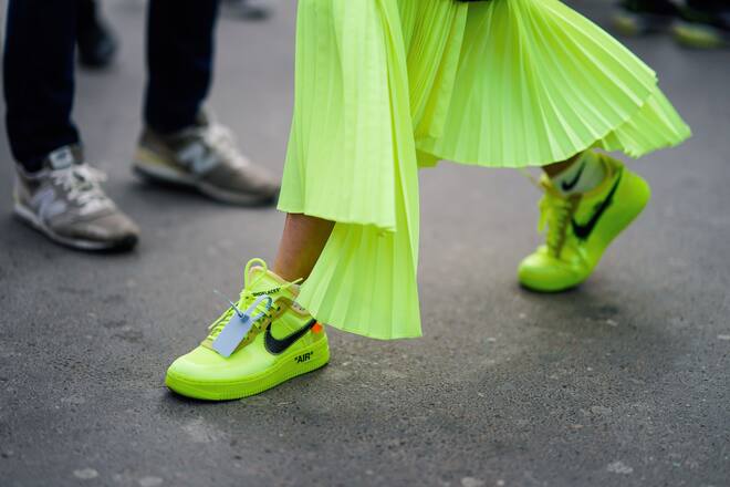 PARIS, FRANCE - FEBRUARY 28: A guest wears a neon green asymmetric pleated skirt, white Nike ankle socks, neon green Nike sneakers, outside Ann Demeulemeester, during Paris Fashion Week Womenswear Fall/Winter 2019/2020, on February 28, 2019 in Paris, France. (Photo by Edward Berthelot/Getty Images)