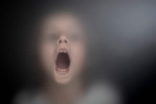 View of scared child through frosted glass
