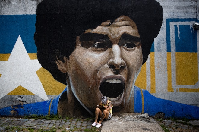 BUENOS AIRES, ARGENTINA - NOVEMBER 25: Argentina footballer of Boca Junior's women's team Yamila Rodriguez cries in front of a graffiti of Diego Maradona after the news of his death was known on November 25, 2020 in Buenos Aires, Argentina. Diego Maradona, considered one of the biggest football stars in history, died at 60 from a heart attack on Wednesday in Buenos Aires. (Photo by Tomas Cuesta/Getty Images)