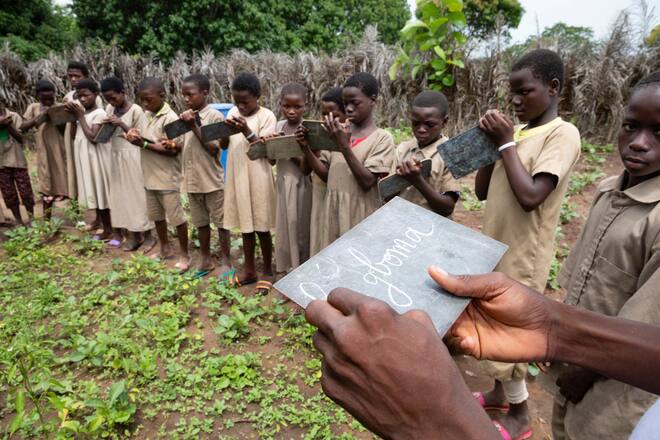 Schulstunde mit Lehrer Guétaba Magnedena im Schülergarten. Le gboma ist eine Art Spinat. Im Dorf Kpakparakpade. Province Centrale, Togo, SRK, Schweizerisches Rotes Kreuz. Foto: Bernard van Dierendonck