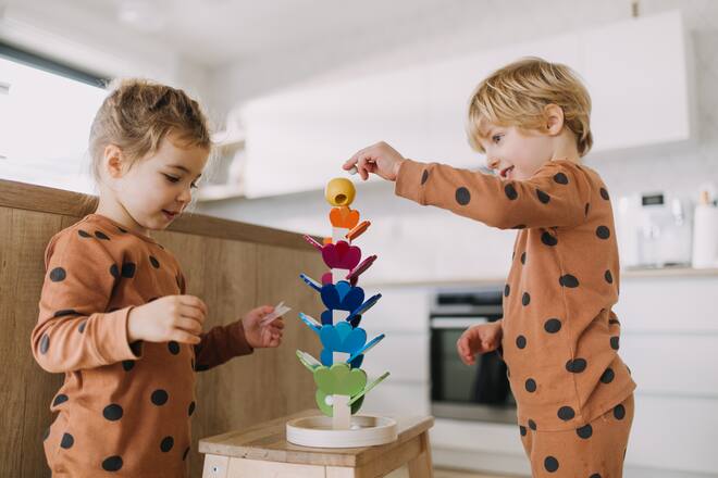 Little girl and boy having fun when playing with Montessori toy.