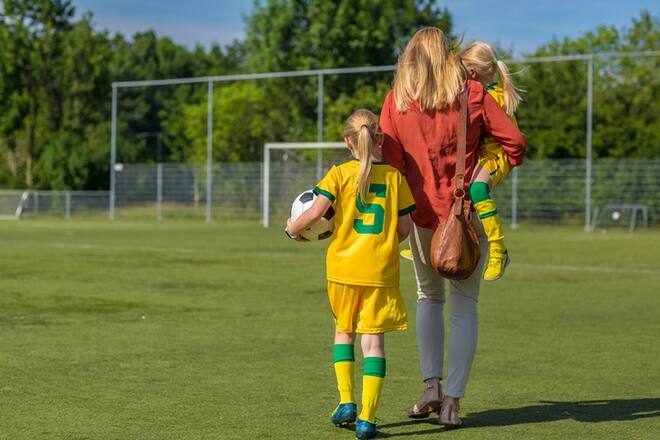 Soccer Mom accompanying her two daughters to football training
